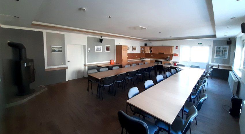 Der Saal im Vereinshaus mit langer Tafel und Kaminofen